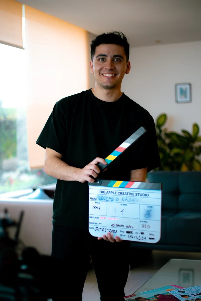 Daniel Baez, Asistente de Dirección, sosteniendo una claqueta en una producción cinematografica de BIg Apple Creative Studio.