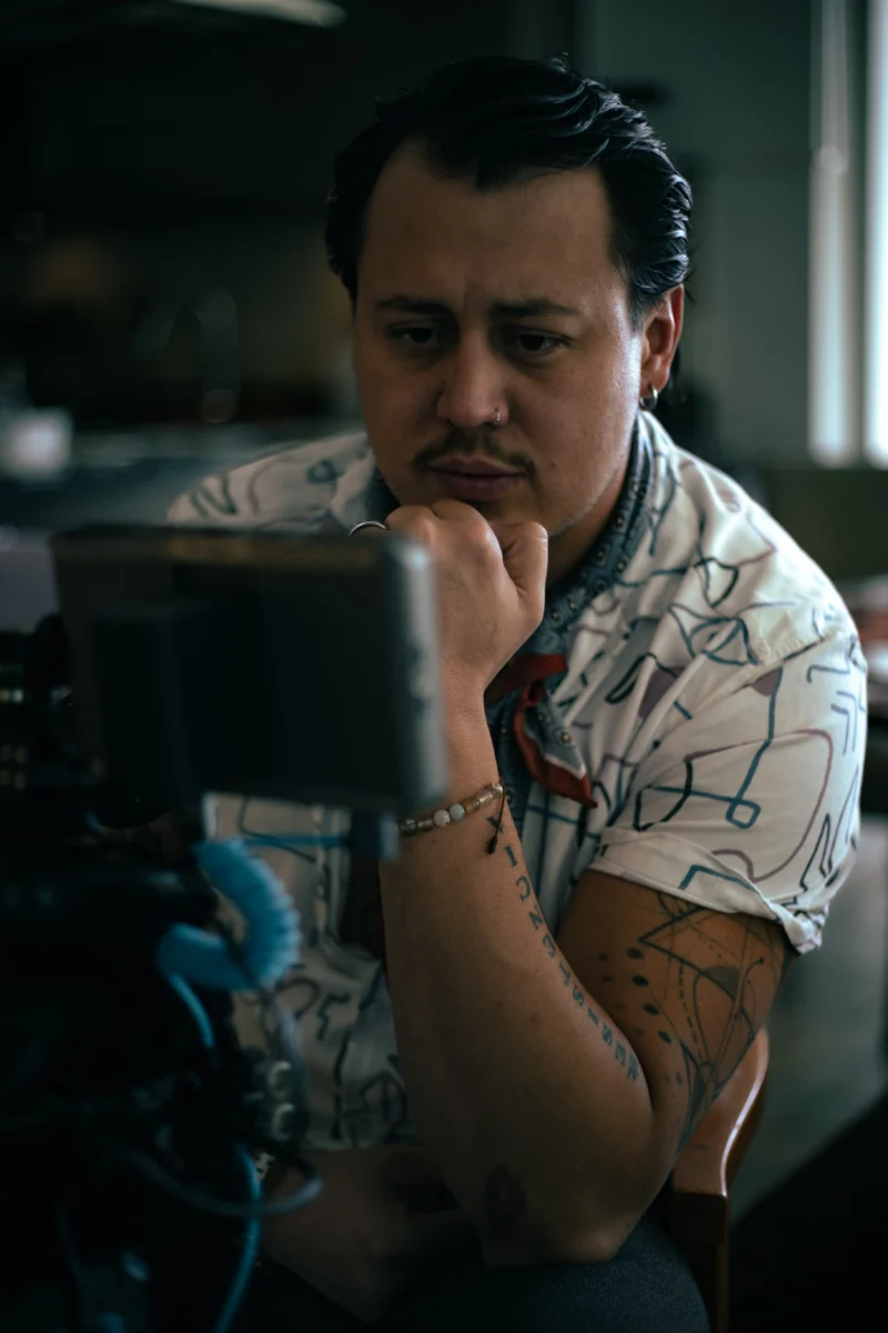 Nick Castells, director y fundador de Big Apple Creative Studio, concentrado frente al monitor de cámara durante una producción cinematográfica profesional en Quito, Ecuador.